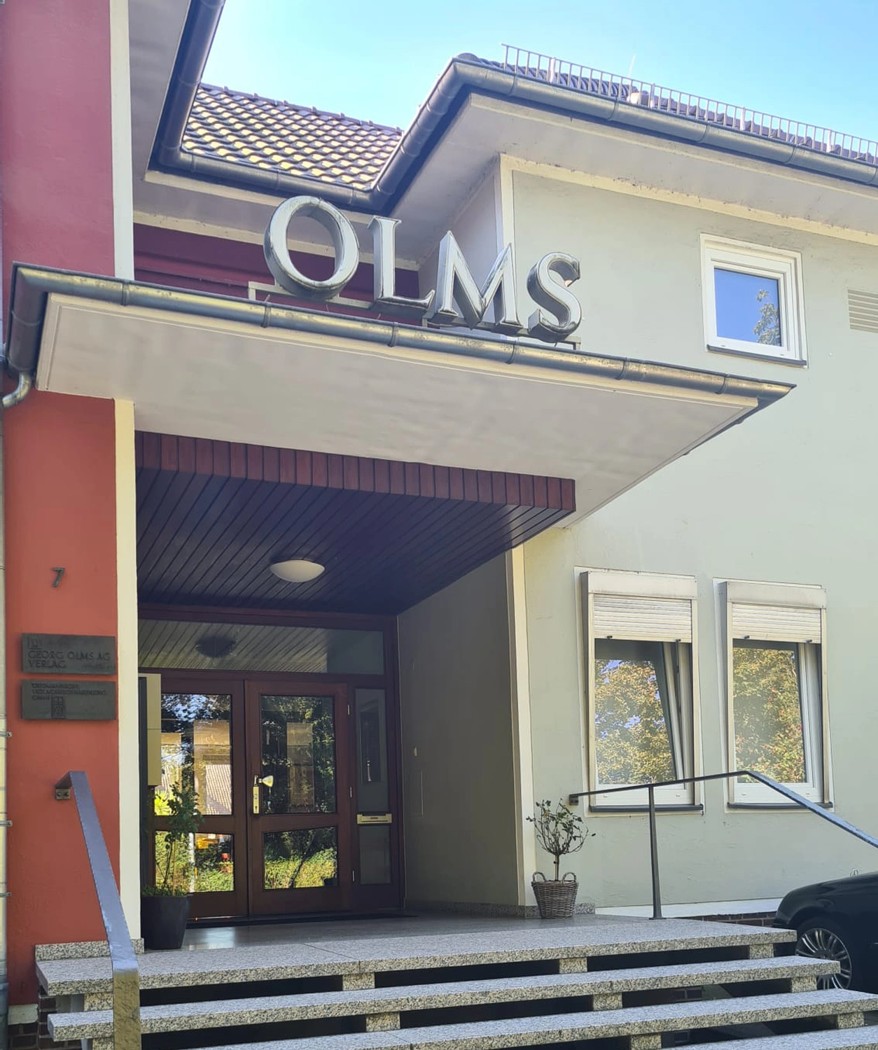 Eingang des Verlagshauses am Hagentorwall 7 mit den Buchstaben „OLMS“ über dem Vordach